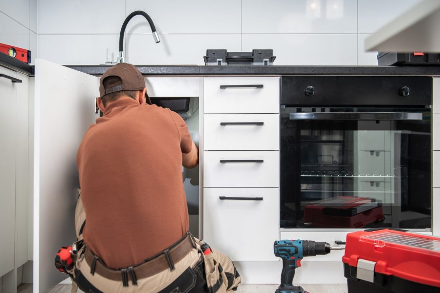 Plumbing Technician Finishing Kitchen Sink Pipeline Installation