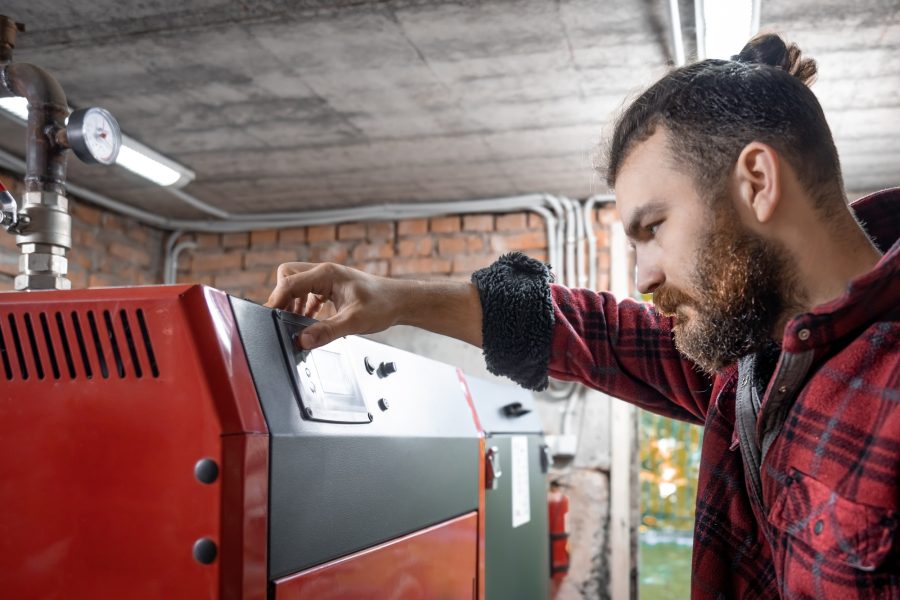 The man with solid fuel boiler, working with biofuels, economical heating.